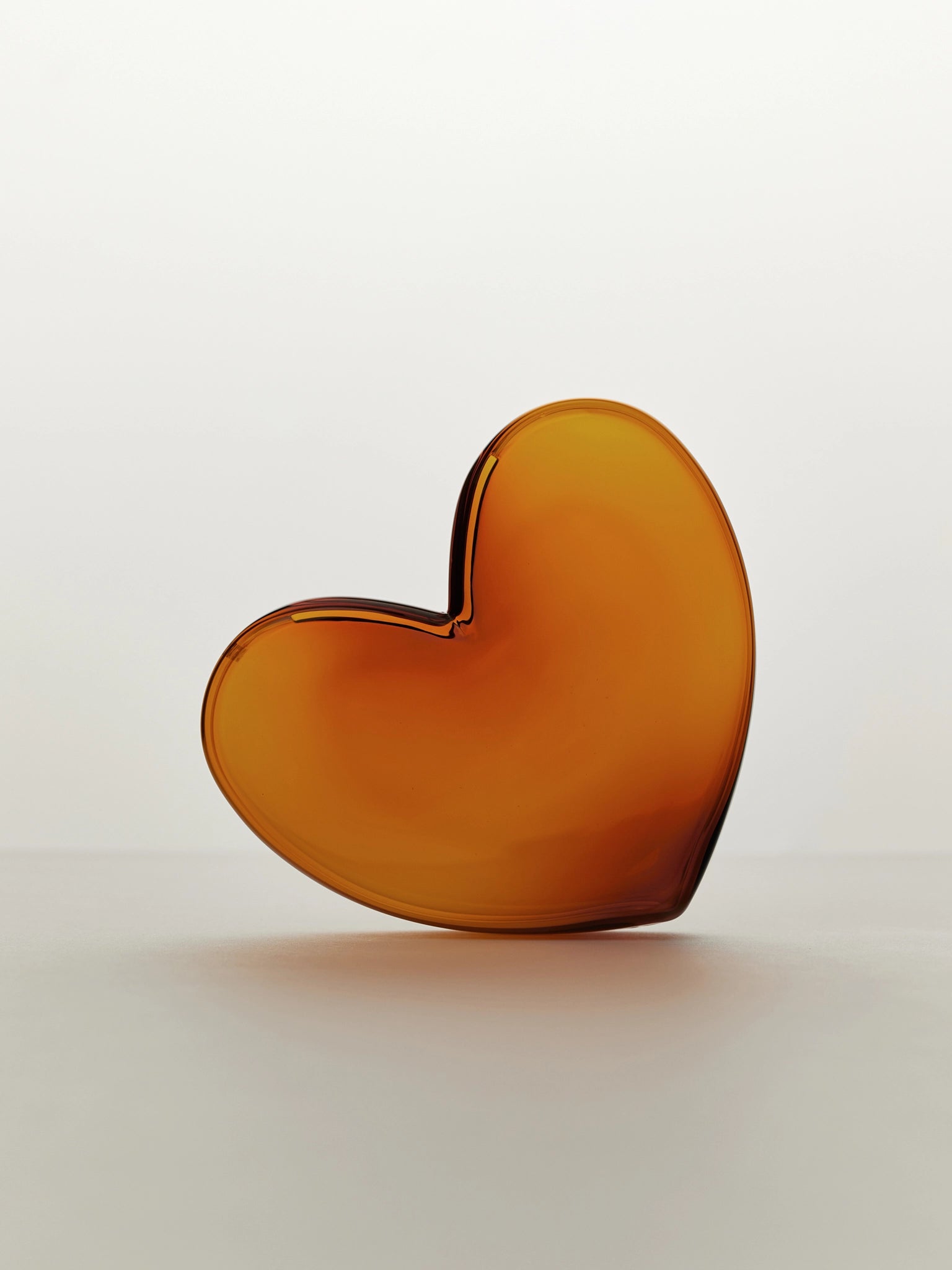 Amber heart-shaped vase on a white background